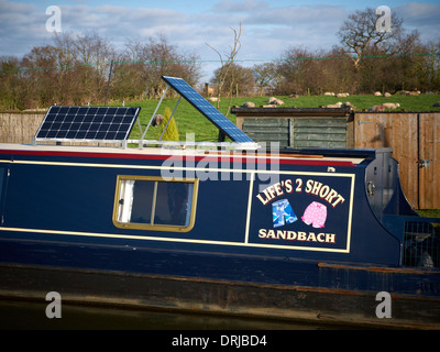 Life`s 2 short for narrow boat with solar panels on the Trent and Mersey canal in Sandbach UK Stock Photo